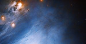 Bright blue cloud fills the scene, orange-red rings surround bright-white stars in the upper-left corner of the image.